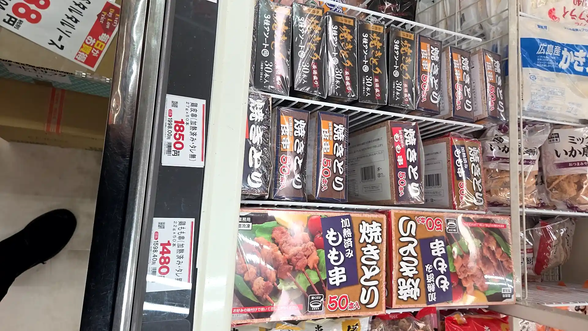業務スーパーの冷凍食品売り場。業務用の焼きとり（もも串・皮串）が50本入りで1,480〜1,850円と大容量で並ぶ冷凍ケース