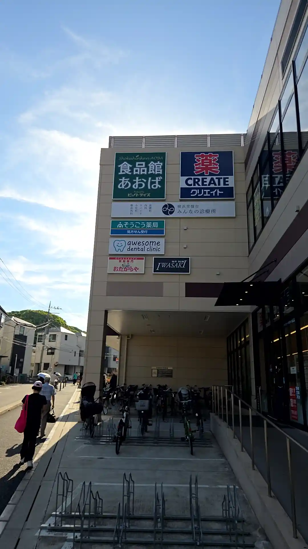 横浜の安いスーパー・食品館あおばの外観。緑の「食品館あおば」の看板と、ドラッグストアのクリエイトや診療所などが入る複合ビル。手前は駐輪場