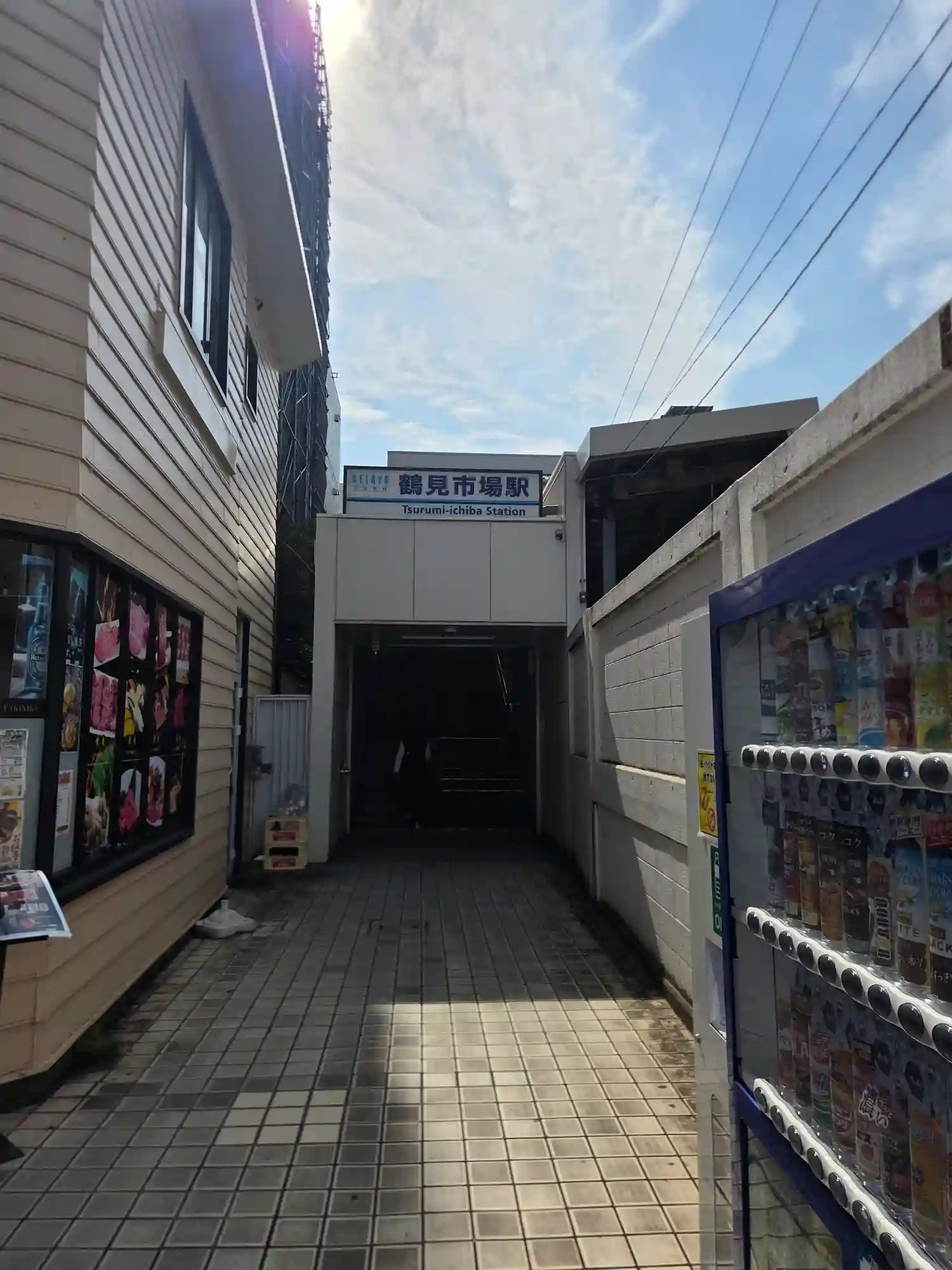 京急本線鶴見市場駅の入口。KEIKYUの駅名看板が掲げられた地上の出入口と、タイル敷きの通路