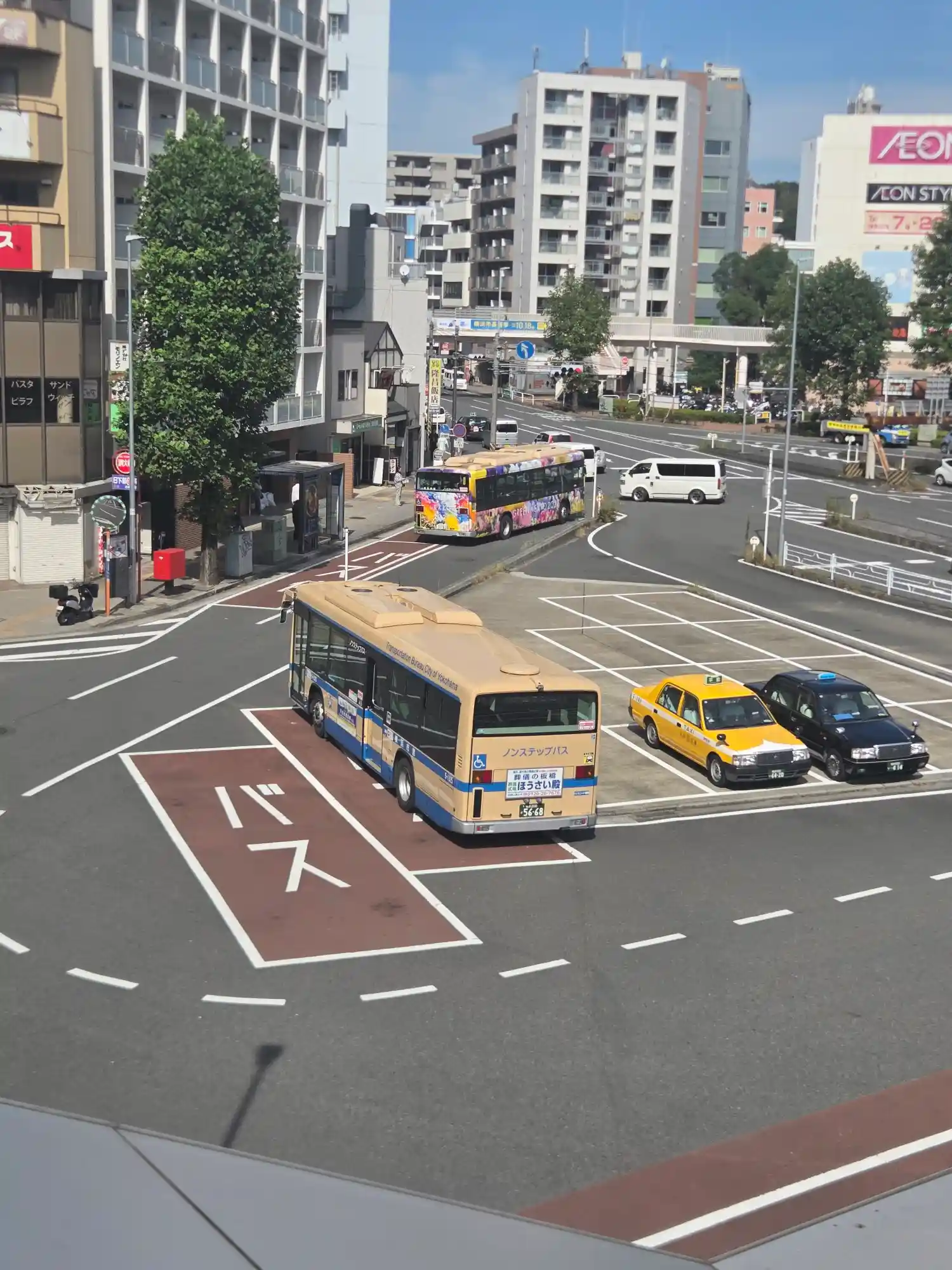 東神奈川駅東口のバスロータリーと奥のイオンスタイル東神奈川。市営バスとタクシーが発着する駅前