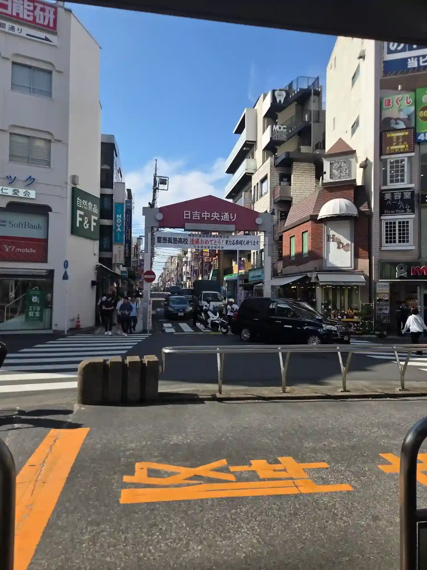 日吉駅前の日吉中央通り商店街の入口アーチ。慶應義塾高校を祝う横断幕が掲げられ、飲食店や商店が並ぶ日吉の商店街