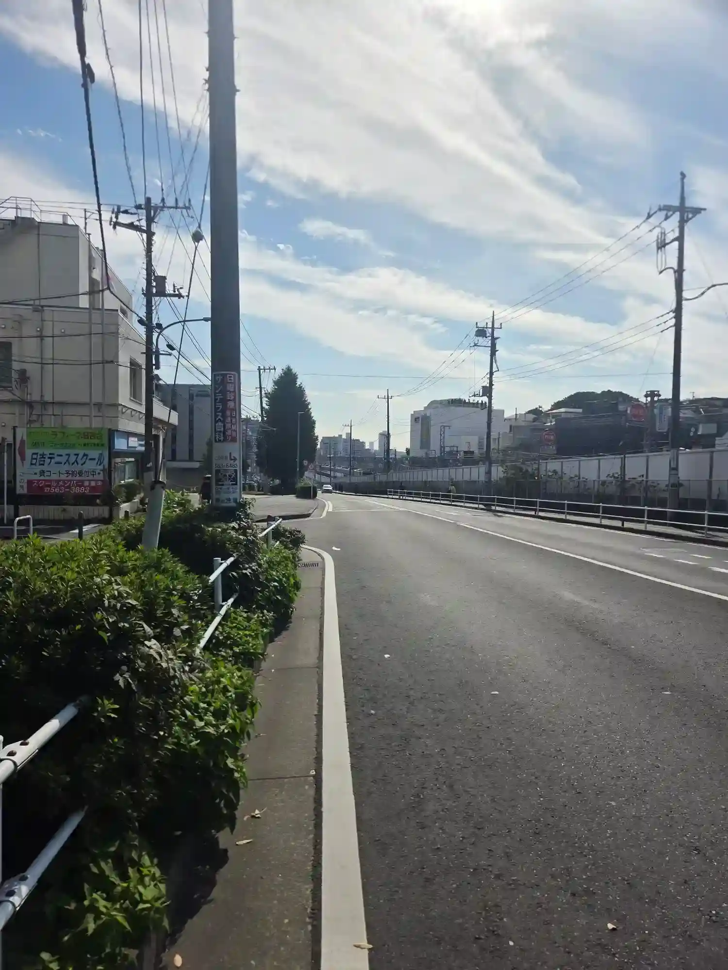日吉駅から少し離れた線路沿いの道路。ゆるやかな起伏があり、駅から離れると坂のある地形になる日吉の街並み