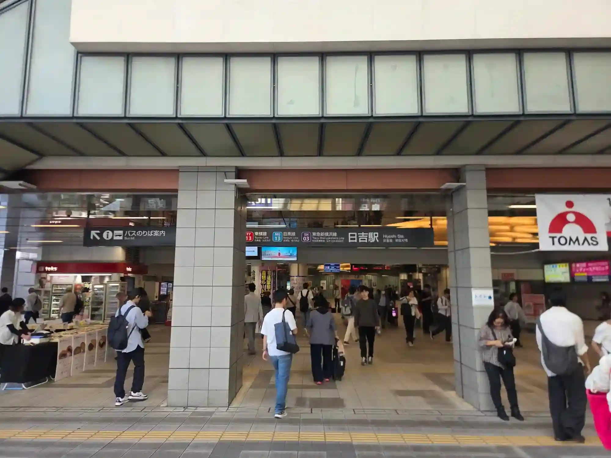 東急日吉駅の改札口。東横線・目黒線・東急新横浜線の3路線の案内看板があり、多くの人が行き交う日吉駅の入口