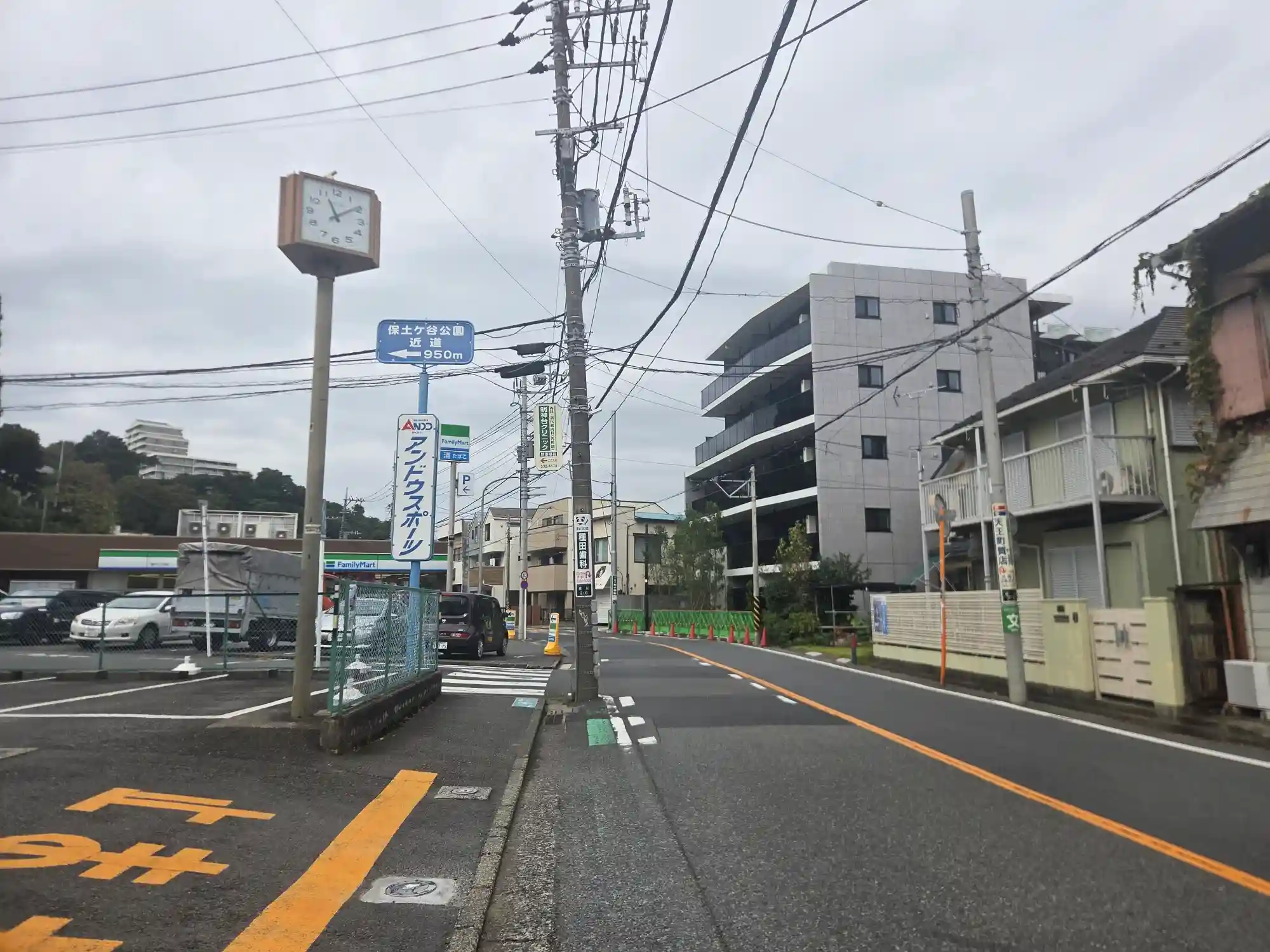 星川駅周辺の住宅街の通り。築浅のマンションと戸建てが混在し、保土ケ谷公園まで950mの案内標識が立つ