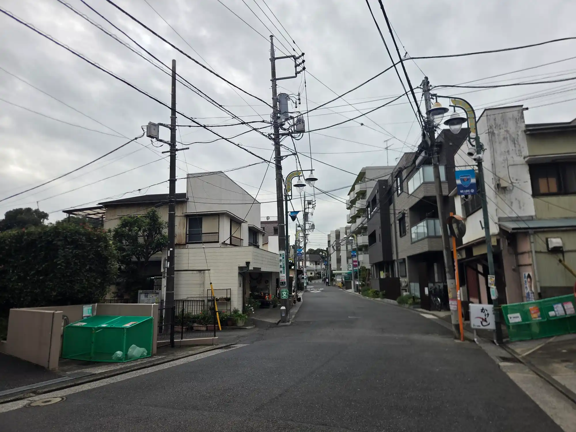 西谷駅近くの街灯が並ぶ通り。個人商店と低層のマンションが混ざる落ち着いた街並み