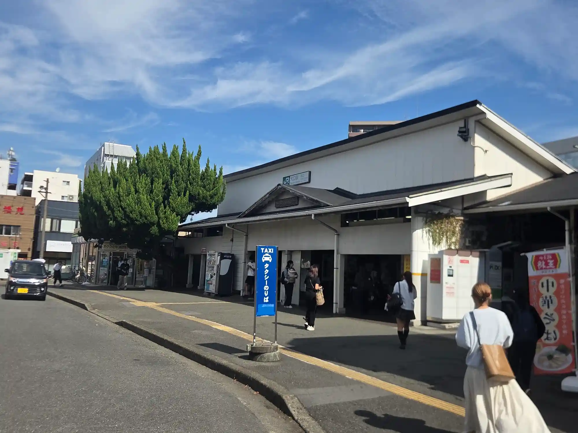 JR横浜線大口駅の駅舎とタクシー乗り場。平屋の小さな駅舎の前を、学生や住民が行き交う