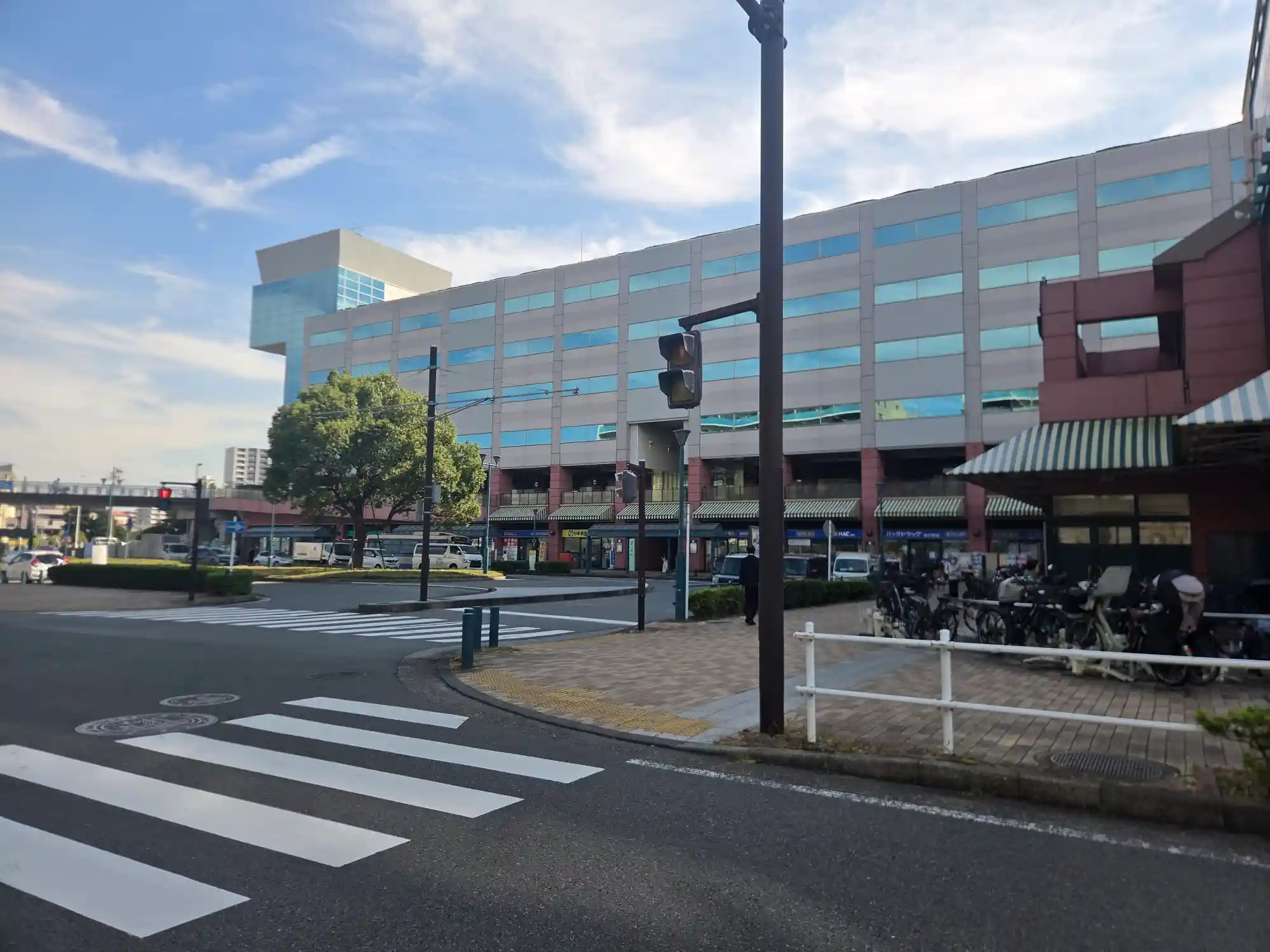 新子安駅北西側の複合施設オルトヨコハマの外観。1階にドラッグストアや飲食店が並び、前にはバスロータリーがある