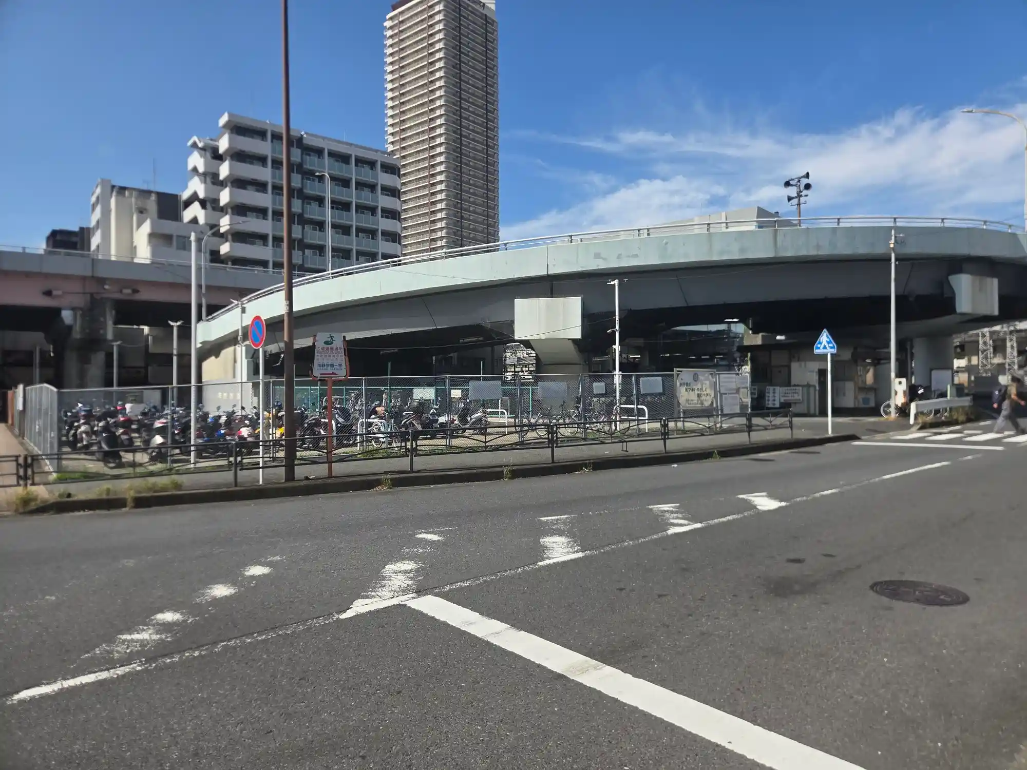 新子安駅の近くを通る高架道路と、その下の駐輪場。背後には高層マンションが建つ