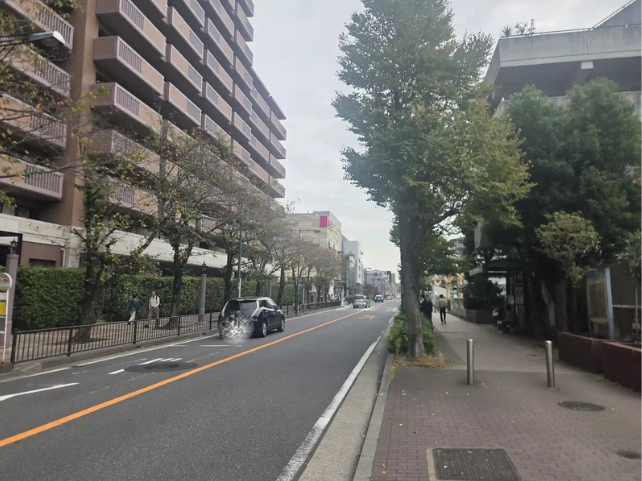 天王町駅周辺の並木がある広い歩道の通り。左にマンションとバス停があり、通りの先にイオン天王町の建物が見える