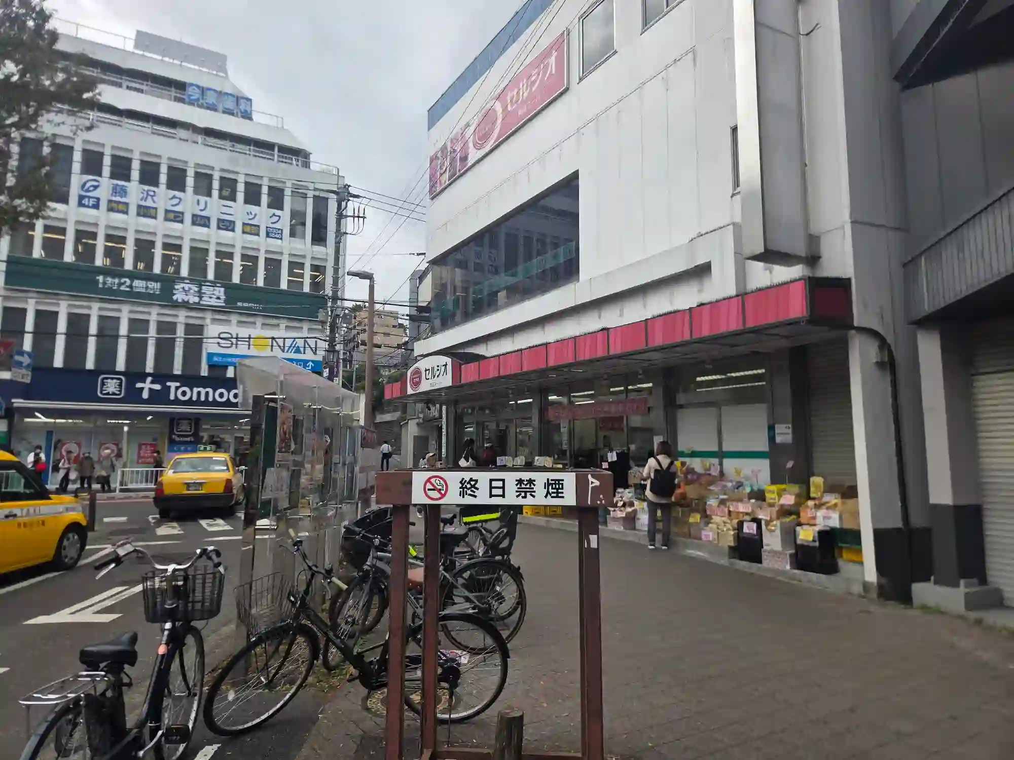 和田町駅前の食品スーパーのセルシオと、道路を挟んだドラッグストアのトモズ。駅前で食品と日用品がそろう
