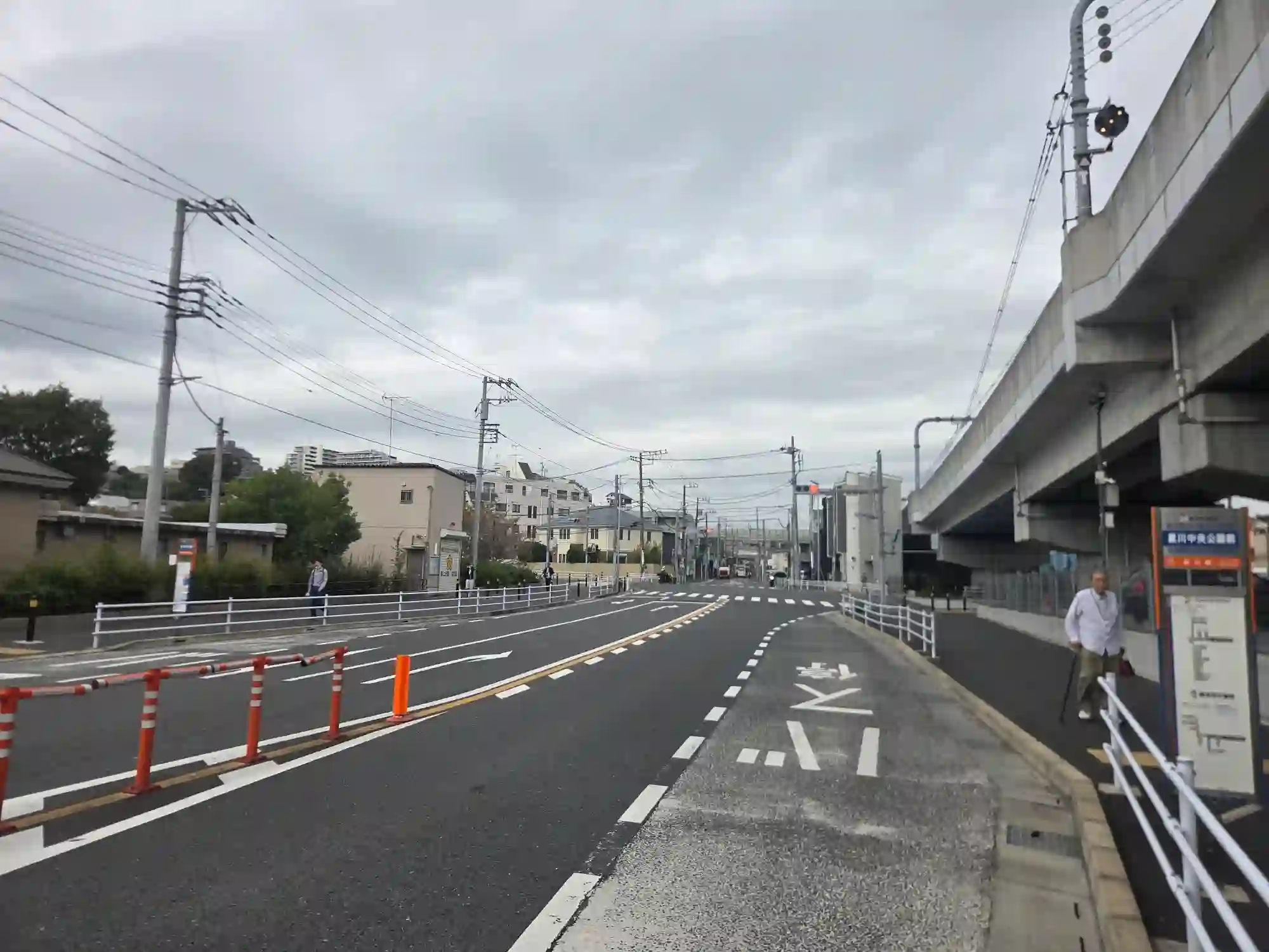 和田町駅から星川方面へ続く道路。右手に相鉄線の高架と星川中央公園前のバス停があり、道幅が広く見通しがよい